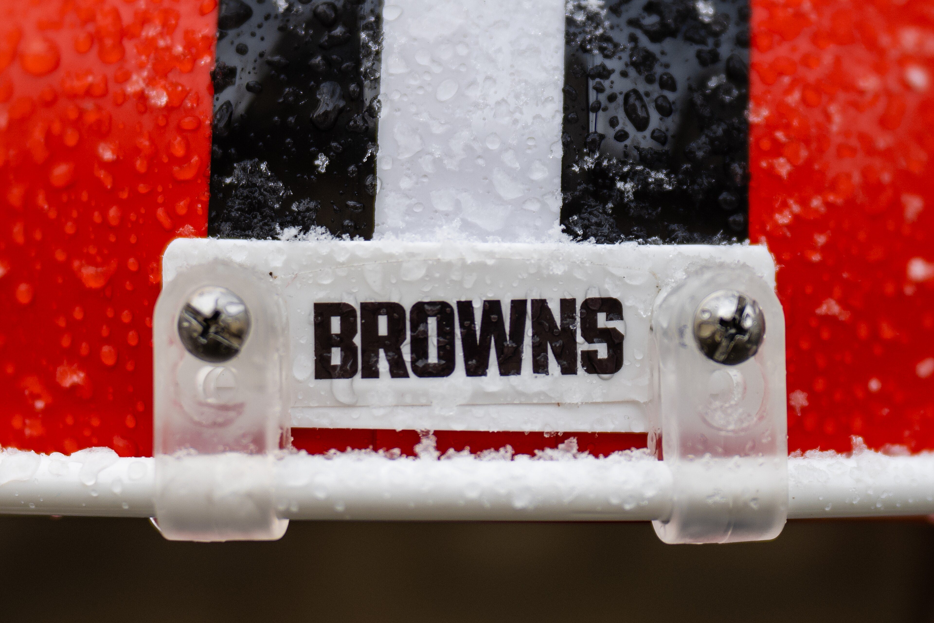 A close view of a snow-covered Cleveland Browns goalpost pad during a January 2024 game.