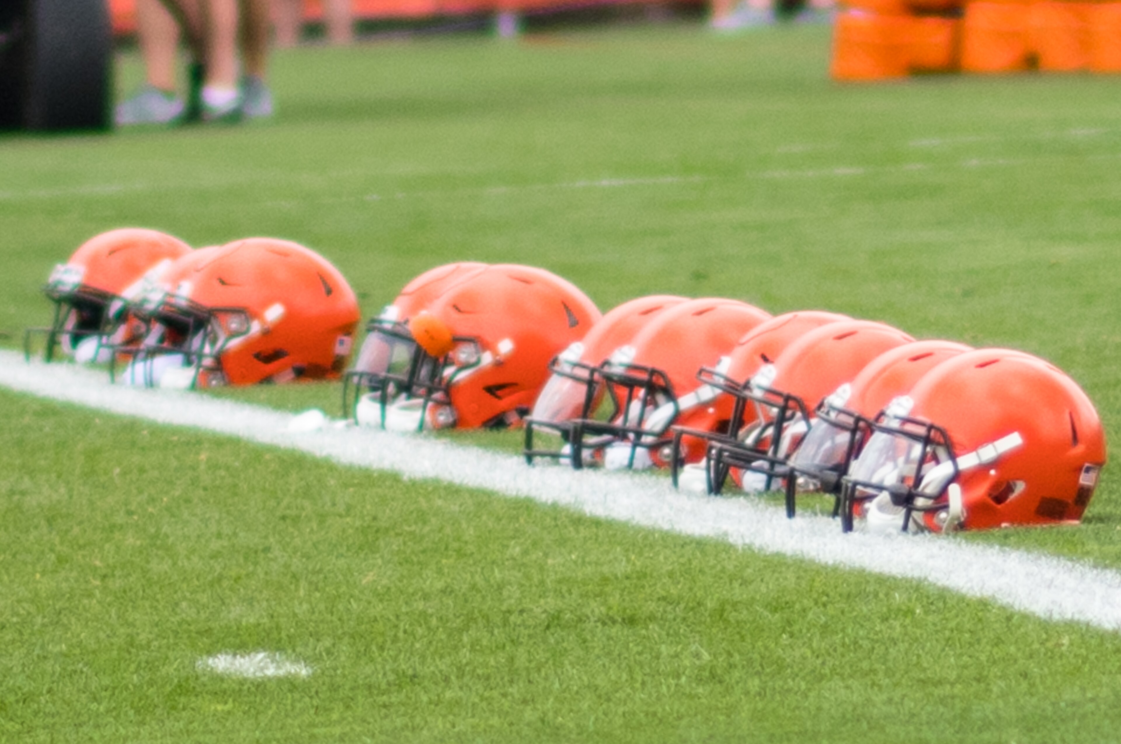 A row of Cleveland Browns helmets rests along the sideline during 2018 training camp.